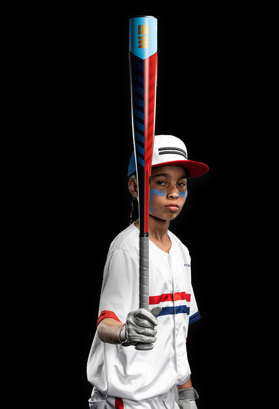 Child baseball player focused ready to bat. Kid holding a baseball